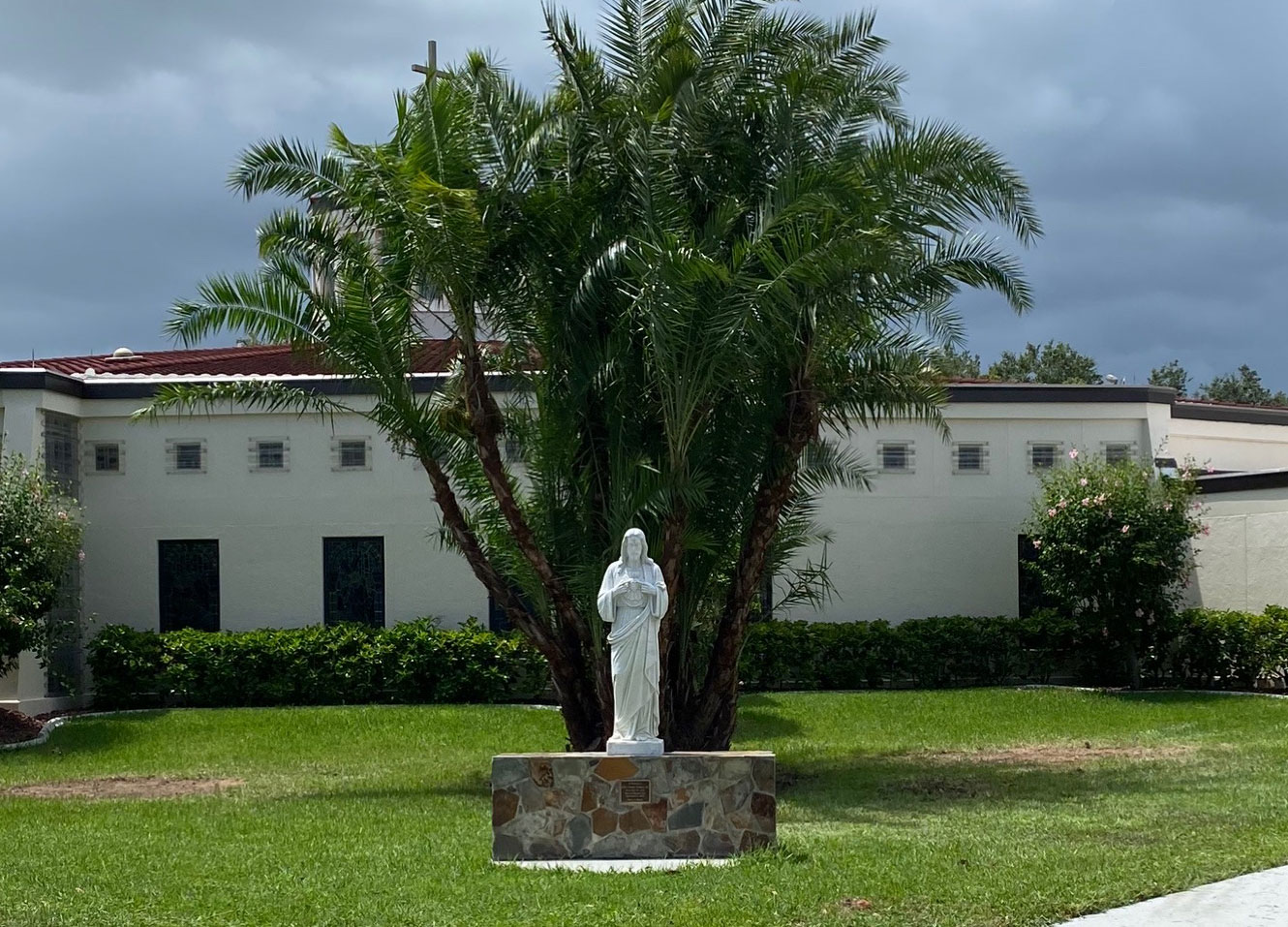 a statue at a church after Coastal Mowing removed 2 trees and installed a new plant