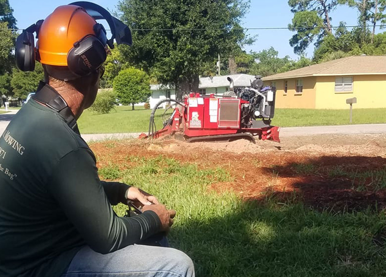 an arborist in Florida taking a break while stump grinding
